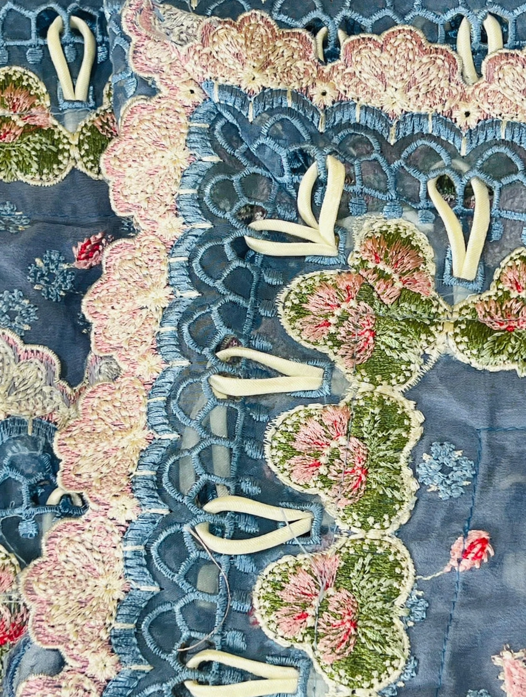 Close-up of Republic dupatta unique loop dori fabric work with cream fabric loops inserted through blue cutwork holes between pink and green floral embroidered patches handmade loop style by Hashtag Happiness tailor Faisalabad