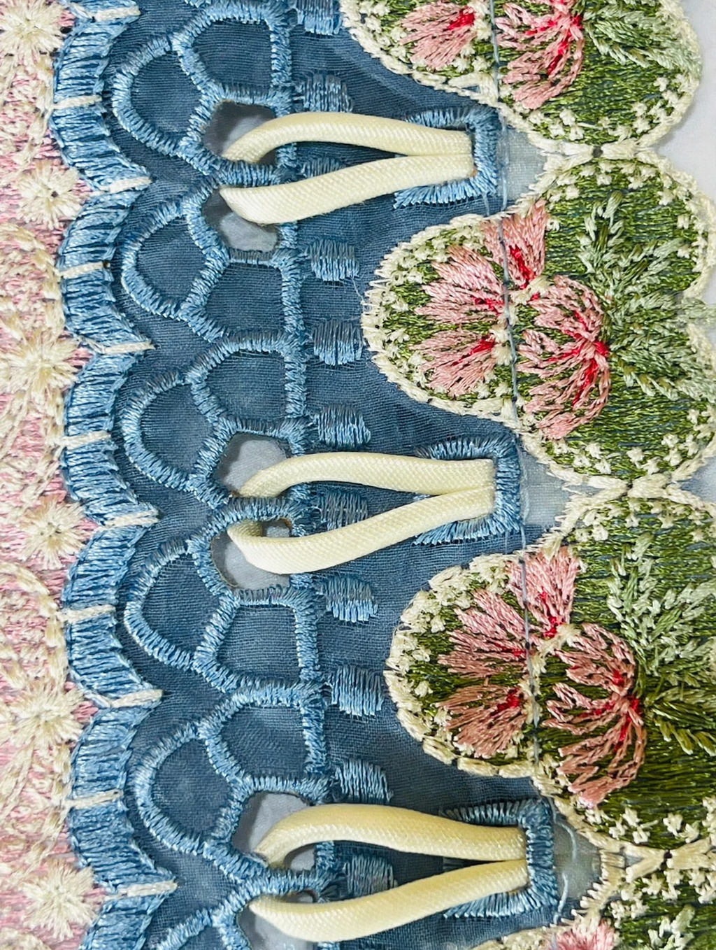 Close-up of Republic dupatta unique loop dori fabric work with cream fabric loops inserted through blue cutwork holes between pink and green floral embroidered patches handmade loop style by Hashtag Happiness tailor Faisalabad
