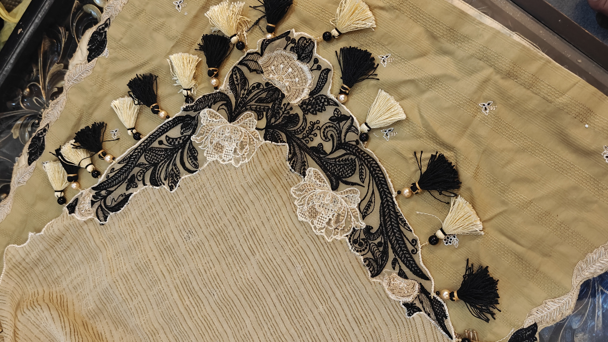 Closeup view of designer corner patch work on beige dupatta with handmade pearl tassels