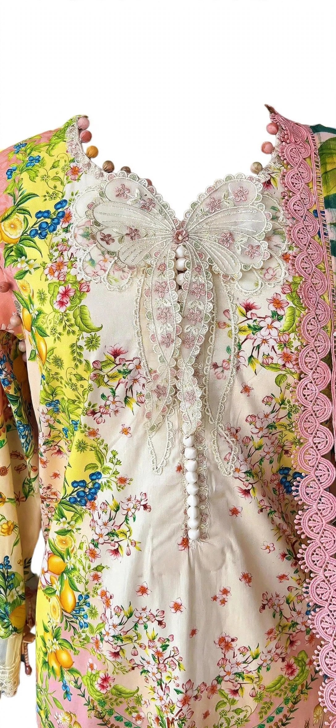 Trending butterfly neckline design with white embroidered butterfly lace motive and white potli buttons on floral printed suit with pink crochet lace - Maria.B hit code custom stitching by Hashtag Happiness Faisalabad