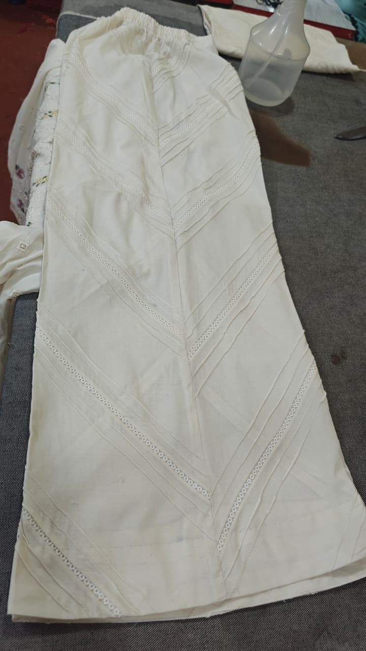 Customized off-white trouser design with V-shape pintex pleats chevron pattern and white crochet lace insertion stitched by Hashtag Happiness Faisalabad boutique tailoring
