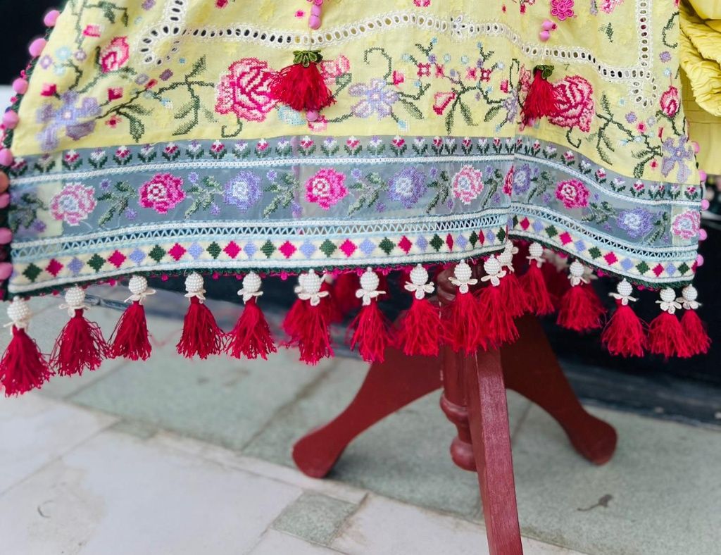 Close up of daman with handmade red resham tassels and pearl beads customization